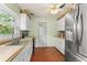 Bright kitchen with stainless steel refrigerator, white cabinets, decorative wallpaper border, and vinyl flooring at 2538 Meadowview Ln, Deland, FL 32720