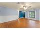 Sunlit living room featuring hardwood floors, a ceiling fan, and large windows with charming curtains at 2538 Meadowview Ln, Deland, FL 32720