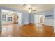 Living room featuring hardwood floors, a ceiling fan, and access to the adjacent kitchen and sunroom at 2538 Meadowview Ln, Deland, FL 32720