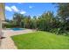Expansive backyard featuring lush lawn, tropical landscaping, and a serene pool area at 25554 Hawks Run Ln, Sorrento, FL 32776