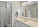 Well-lit bathroom with a spacious vanity, a large mirror, and a separate shower room at 25554 Hawks Run Ln, Sorrento, FL 32776