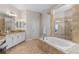 Primary bathroom featuring double vanities, a soaking tub, and a walk-in shower with tile surround at 25554 Hawks Run Ln, Sorrento, FL 32776