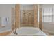 Bathroom features a tiled walk-in shower and jetted soaking tub with tile surround at 25554 Hawks Run Ln, Sorrento, FL 32776