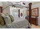 Bedroom with an ornate four-poster bed, neutral walls, and a tray ceiling with a fan at 25554 Hawks Run Ln, Sorrento, FL 32776