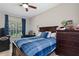 Comfortable bedroom with a blue striped bed, a dedicated computer desk, and a classic arcade game console at 25554 Hawks Run Ln, Sorrento, FL 32776