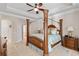 Bedroom with a four-poster bed, ceiling fan, and private bathroom access at 25554 Hawks Run Ln, Sorrento, FL 32776