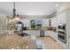 Modern kitchen featuring granite countertops, stainless steel appliances, and white cabinets at 25554 Hawks Run Ln, Sorrento, FL 32776