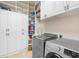 Efficient laundry room with modern washer and dryer, plenty of cabinet space, and a convenient utility sink at 25554 Hawks Run Ln, Sorrento, FL 32776