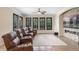 Beautiful living room with leather seating, a ceiling fan, and a stacked stone fireplace with a large screen TV at 25554 Hawks Run Ln, Sorrento, FL 32776
