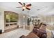 Open concept living room boasts a brick fireplace, large screen tv, and a view into the kitchen and dining area at 25554 Hawks Run Ln, Sorrento, FL 32776