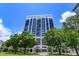 Modern building exterior with large windows, landscaped lawn, and vibrant blue sky at 260 S Osceola Ave # 902, Orlando, FL 32801