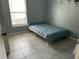 A bedroom featuring a window, light blue walls, and tile flooring at 2833 Woodruff Dr, Orlando, FL 32837