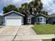 Charming single-story home featuring a well-maintained lawn, two palm trees, and a quaint blue exterior at 2833 Woodruff Dr, Orlando, FL 32837