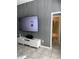 Stylish living room featuring a mounted TV, modern credenza, and a door to a tiled bathroom at 2833 Woodruff Dr, Orlando, FL 32837