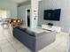 Living room featuring tiled floors, dining table, modern decor, and a grey couch at 2833 Woodruff Dr, Orlando, FL 32837