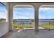 Balcony with stone floors and arched railings, offering views of the lake, lawn, and boat docks at 2937 Butler Bay N Dr, Windermere, FL 34786
