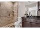 Elegant bathroom featuring a glass-enclosed shower, dark vanity and granite countertops at 2937 Butler Bay N Dr, Windermere, FL 34786