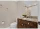 Powder room with dark wood vanity, granite countertop, toilet, and towel holders at 2937 Butler Bay N Dr, Windermere, FL 34786