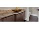 Stylish bathroom showcasing a unique vessel sink, wood cabinets, and granite counter at 2937 Butler Bay N Dr, Windermere, FL 34786