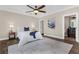 Well-lit bedroom features a ceiling fan, white bedding, and dark wood floors at 2937 Butler Bay N Dr, Windermere, FL 34786