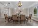 Elegant dining room with an ornate chandelier, tray ceilings, and ample natural light at 2937 Butler Bay N Dr, Windermere, FL 34786