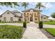 Magnificent two-story home with palm trees, meticulously kept landscaping, and a paver walkway at 2937 Butler Bay N Dr, Windermere, FL 34786