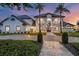 Stunning two-story home with a manicured lawn, large driveway, and a grand entrance framed by palm trees at 2937 Butler Bay N Dr, Windermere, FL 34786