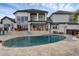 Rear view of the home shows expansive backyard, in-ground pool, and outdoor patio at 2937 Butler Bay N Dr, Windermere, FL 34786