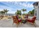Outdoor seating surrounding stone fire pit overlooks landscaped yard, serene lake, and relaxing hot tub at 2937 Butler Bay N Dr, Windermere, FL 34786