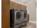 Spacious laundry room equipped with front loading washer and dryer and custom cabinets at 2937 Butler Bay N Dr, Windermere, FL 34786