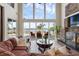Lake view living room featuring a stone fireplace, comfortable seating, and lots of natural light at 2937 Butler Bay N Dr, Windermere, FL 34786