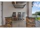 A stainless steel outdoor grill is built into a stone base, adding a luxurious feel to the outdoor kitchen at 2937 Butler Bay N Dr, Windermere, FL 34786