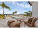 Outdoor seating on patio with a view of the pool, spa, and lake with palm trees adding to the scenery at 2937 Butler Bay N Dr, Windermere, FL 34786
