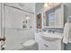 Updated bathroom featuring a white shower, toilet and sink with white cabinet and brushed nickel fixtures at 3010 Brandywine Dr, Orlando, FL 32806