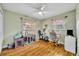 Cozy bedroom with wood floor featuring an exercise area, closet, small dog crate and natural light at 3010 Brandywine Dr, Orlando, FL 32806