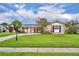 Charming single-story home featuring a well-manicured lawn, complemented by blooming plants and mature trees under a bright, cloudy sky at 3010 Brandywine Dr, Orlando, FL 32806