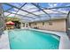 Lovely screened-in pool with poolside chairs, surrounded by a spacious deck and beautiful blue water at 3010 Brandywine Dr, Orlando, FL 32806
