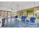 Bright sunroom featuring blue tile floor, ceiling fans, white furniture, and lots of natural light at 3010 Brandywine Dr, Orlando, FL 32806