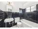 Bathroom with black tiling, vintage fixtures, and a clean, classic design at 311 Cortland Ave, Winter Park, FL 32789