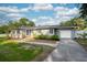 Charming gray single-story home with a well-manicured lawn, front garden, and attached garage at 311 Cortland Ave, Winter Park, FL 32789