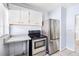 Well-lit kitchen featuring stainless steel refrigerator and black stove at 311 Cortland Ave, Winter Park, FL 32789