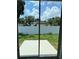 View of the fenced backyard with concrete patio seen through sliding glass doors at 320 W Necho Ave, Lake Alfred, FL 33850