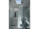 Bright bathroom featuring marble floors, modern vanity, and a glass shower beneath a skylight for a spa-like experience at 320 W Necho Ave, Lake Alfred, FL 33850