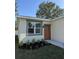 Close up of a house with neutral colored trim around a large window and matching colored door at 320 W Necho Ave, Lake Alfred, FL 33850