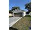 Single Gathering home on green lawn with a long concrete driveway and light colored exterior paint job at 320 W Necho Ave, Lake Alfred, FL 33850