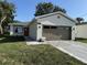 A charming home featuring new landscaping, neutral paint, a brown garage door and a matching front door at 320 W Necho Ave, Lake Alfred, FL 33850