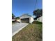 Single Gathering home on green lawn with a long concrete driveway and light colored exterior paint job at 320 W Necho Ave, Lake Alfred, FL 33850