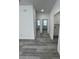 A bright hallway with light gray floors leads to bedrooms and a laundry area at 320 W Necho Ave, Lake Alfred, FL 33850