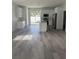 Bright kitchen featuring white cabinets, stainless steel appliances, and hardwood flooring at 320 W Necho Ave, Lake Alfred, FL 33850