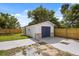 Detached garage boasts a blue door and stone accents adding character to the backyard at 338 Henry Butts Dr, Daytona Beach, FL 32114